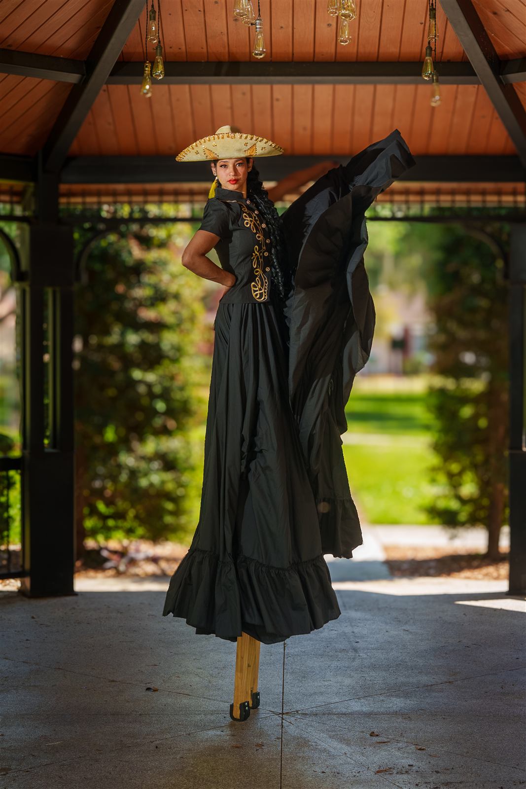Zanquera con sombrero y vestido negro