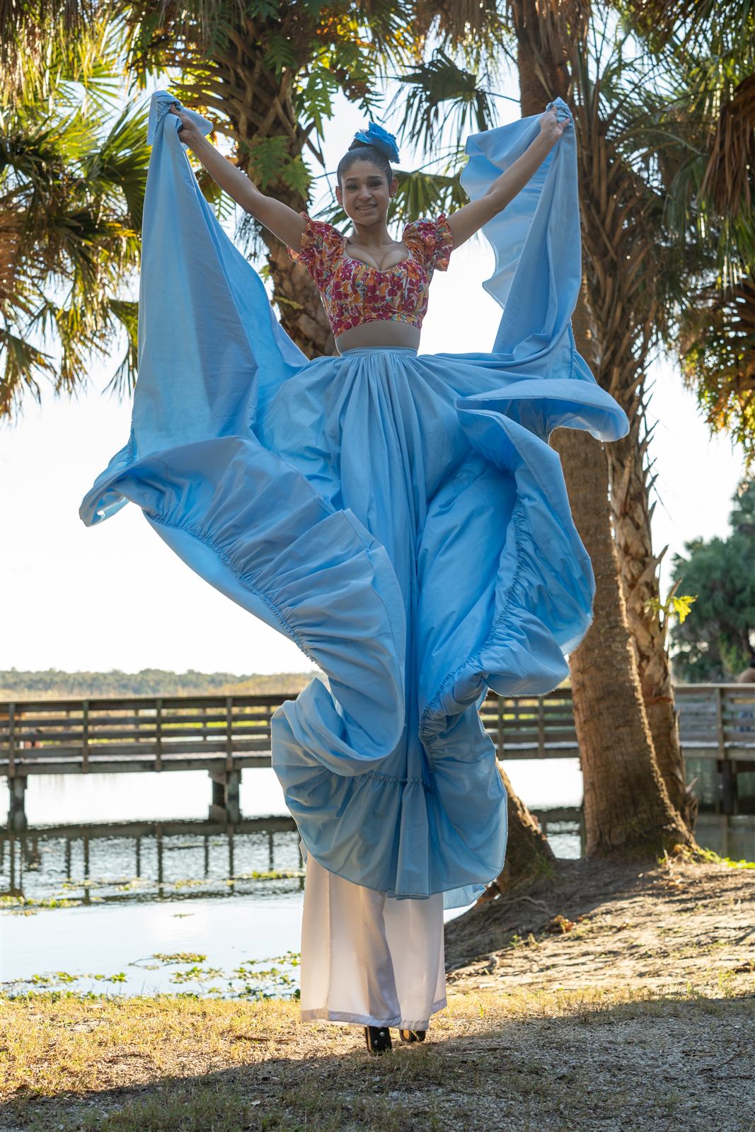 Zanquera con falda azul junto al lago